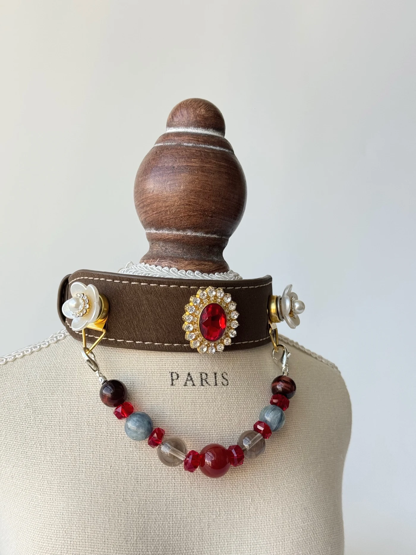 Red Agate & Blue Stone collar on a display bust with a red centre ornament, white flowers and a hanging bead strand