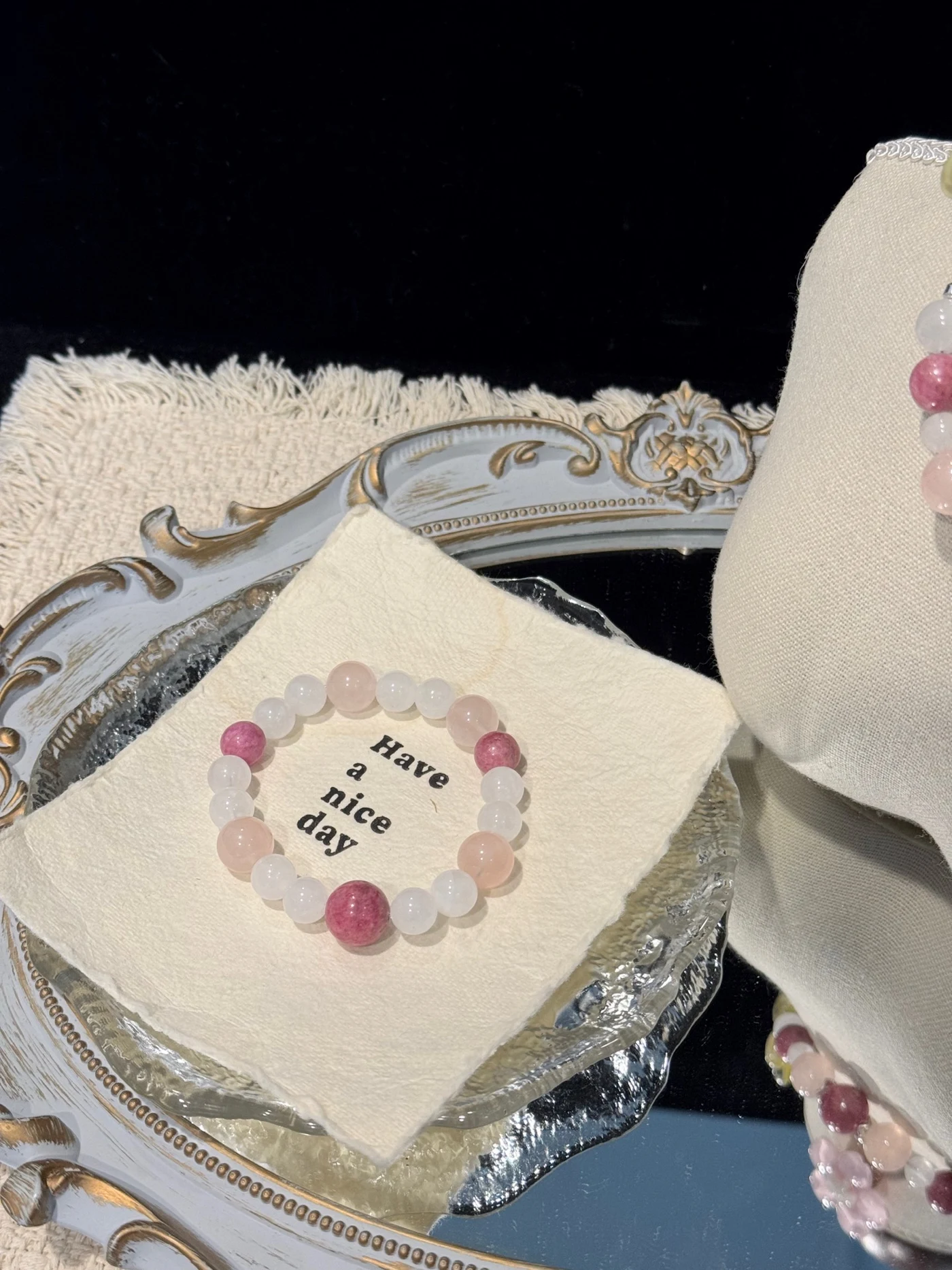 Pink and white Rose Quartz Garden bracelet on an ivory cushion in a decorative tray