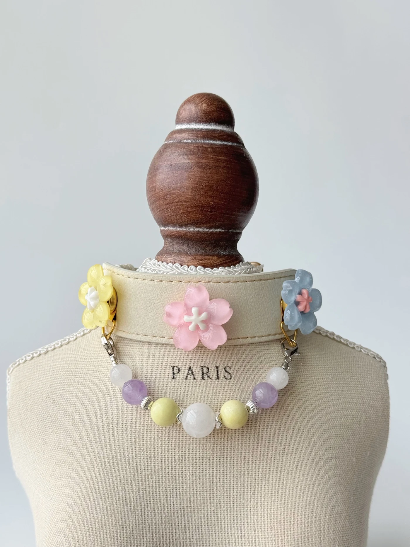 Elfenbeinfarbenes Lavender Crystal Halsband mit pastellfarbenen Blüten sowie weißen, lila und gelben Perlen an einer Büste